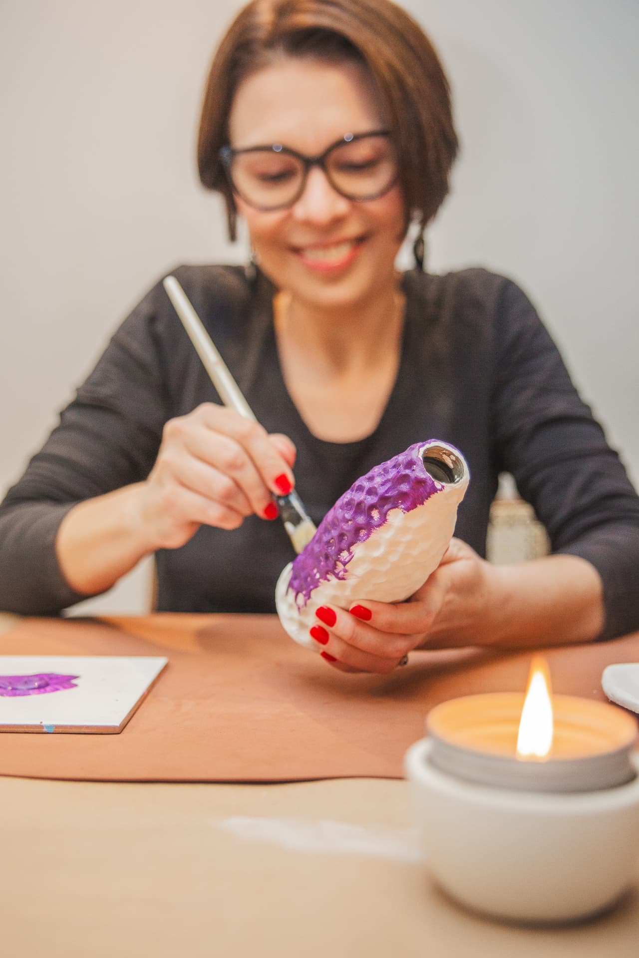Maria Elisa Bonafim pintando uma peça no ateliê